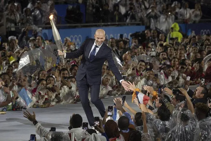 Sport Bilder des Tages July 26, 2024, Paris, Ile de France, France: Soccer great ZINEDINE ZIDANE carries the torch at the Paris 2024 Olympics opening ceremony in the rain on July 26, 2024. Paris France - ZUMAh234 20240726_oly_h234_004 Copyright: xMarkxEdwardxHarrisx