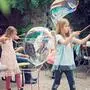 Kinder spielen mit Riesenseifenblasen