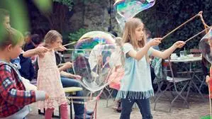 Kinder spielen mit Riesenseifenblasen