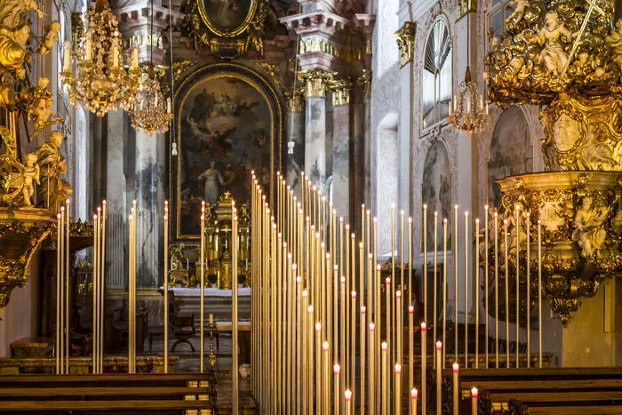 Die Kerzen aus rotem, leicht rinnendem Wachs sollen den Stelen entlang ihre Spuren hinterlassen und so den Eindruck von „geronnenem Blut“ hinterlassen – ein Hinweis auf den Karfreitag. 