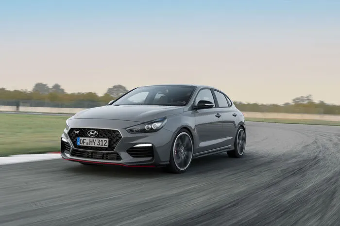 Der i30 Fastback N auf 18 oder 19 Zoll großen Leichtmetallfelgen. Der Kühlergrill ist ganz in Schwarz gehalten und mit dem N-Logo in Form einer Rennstreckenschikane bestückt. Die Voll-LED-Scheinwerfer verfügen über eine schwarz eingefärbte Blende.
