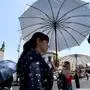 People protect themselves from the sun with an umbrella as they walk during a heat wave hitting the country in Guadalajara, Jalisco State, Mexico, on May 23, 2024. (Photo by ULISES RUIZ / AFP)
