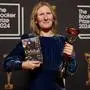 Samantha Harvey poses with the trophy and her book "Orbital" after winning the Booker Prize award 2024, in London, Tuesday, Nov. 12, 2024. (AP Photo/Alberto Pezzali)