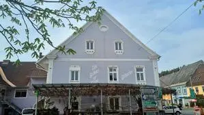 Man sieht ein Gasthaus und einen großen Sitzgarten