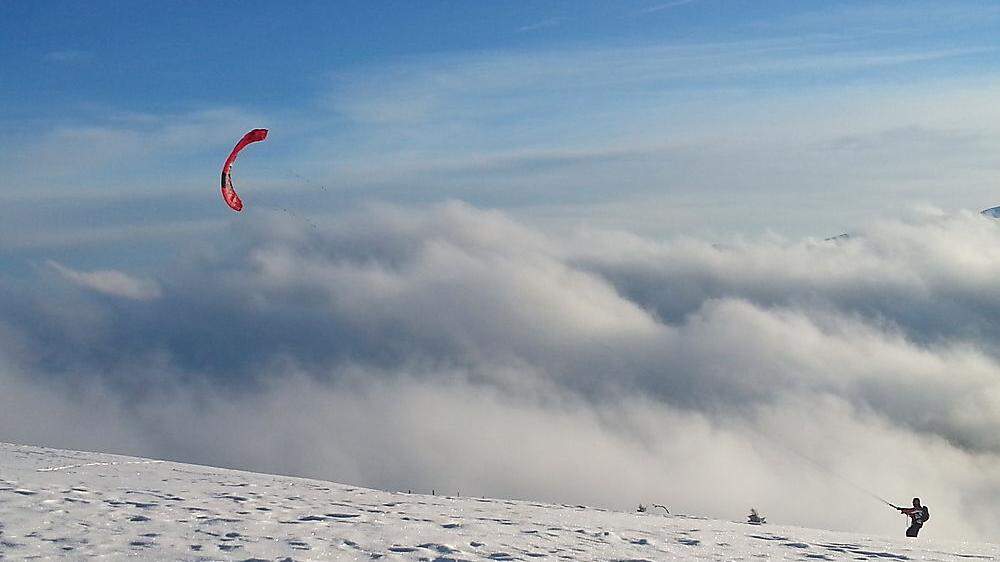 Von einem Drachen lassen sich Snowkiter über verschneite Almwiesen ziehen - wie hier auf der Saualm