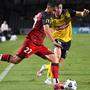 Josh Cavallo of United competes for possession with Daniel Bouman of the Mariners 