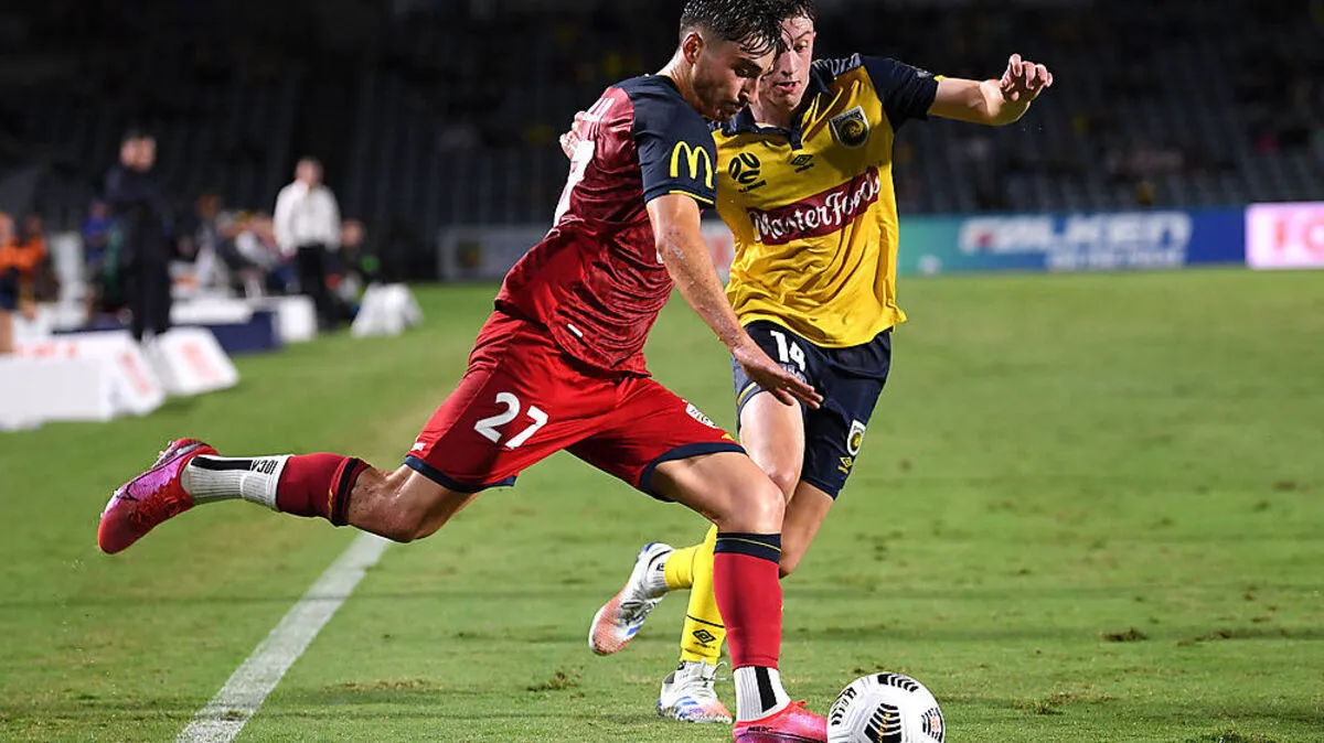 Josh Cavallo of United competes for possession with Daniel Bouman of the Mariners 