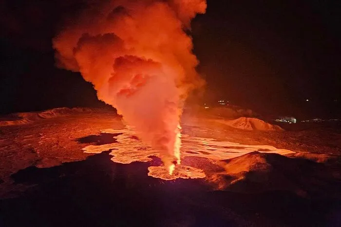 Billowing smoke and flowing lava are seen pouring out of a new fissure in this Icelandic Department of Civil Protection and Emergency Management , February 8, 2024, handout image during a new volcanic eruption on the outskirts of the evacuated town of Grindavik, western Iceland. A volcanic eruption started on the Reykjanes peninsula in southwestern Iceland on Thursday, the third to hit the area since December, authorities said. (Photo by Icelandic Department of Civil Protection and Emergency Management / AFP)