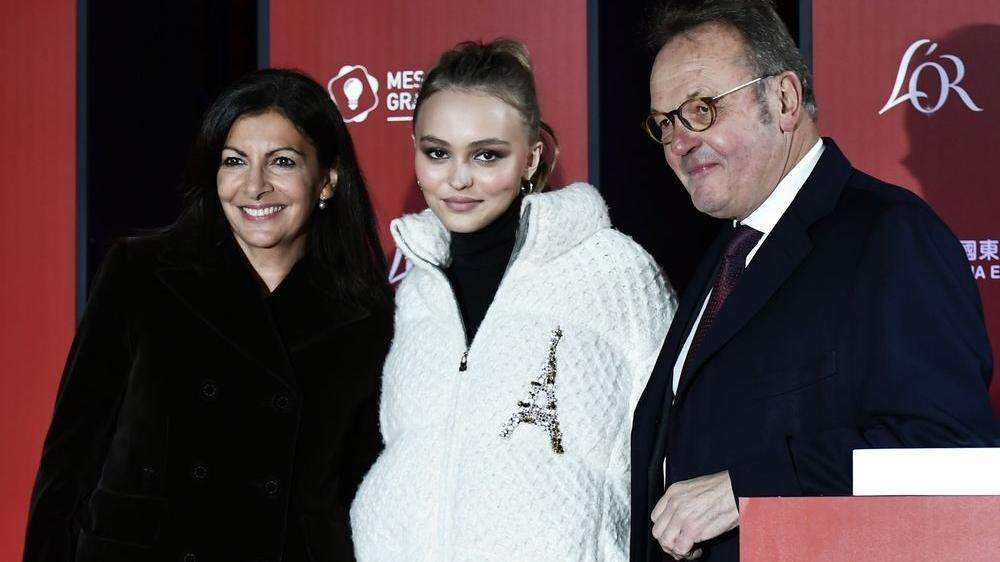Schauspielerin und Model Lily-Rose Depp posiert mit der Pariser Bürgermeisterin Anne Hidalgo (links) und dem Präsidenten des Champs-Élysées Kommittees Jean-Noel Reinhardt 