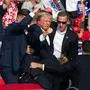 TOPSHOT - Republican candidate Donald Trump is seen with blood on his face surrounded by secret service agents as he is taken off the stage at a campaign event at Butler Farm Show Inc. in Butler, Pennsylvania, July 13, 2024. Republican candidate Donald Trump was evacuated from the stage at today's rally after what sounded like shots rang out at the event in Pennsylvania, according to AFP.
The former US president was seen with blood on his right ear as he was surrounded by security agents, who hustled him off the stage as he pumped his first to the crowd.
Trump was bundled into an SUV and driven away. (Photo by Rebecca DROKE / AFP)