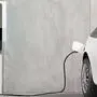 Futuristic electric car connected to the charging station to charge the battery against the background of a concrete wall. 3d render.