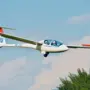 Ein Segelflugzeug fliegt durch die Lüfte. Zwei Menschen fliegen mit ihm.