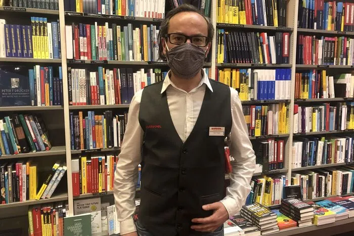 Thomas Tieber, Buchhandlung Moser:Nach dem Lockdown konnte man sich beim Einkaufen schon an die Maske gewöhnen, aber jetzt den ganzen Arbeitstag über eine zu tragen, war eine Umstellung. In den Pausen kann man im Freien durchschnaufen. Das Hauptproblem ist die recht schwierige Verständigung, und es ist eben ein sehr kommunikativer Beruf. Auch die Mimik in Kundengesprächen fehlt. Wer seine Maske vergisst, bekommt eine von uns. Die meisten Kunden entschuldigen sich dann. Leider gibt es auch ein paar schwarze Schafe, die nicht sozial denken und keine Maske tragen wollen. Die Mehrheit hat sich aber anscheinend sowieso an die Maske gewöhnt und immer eine dabei.