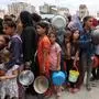 TOPSHOT - Palestinians, most of them children, queue in front of a hot meal distribution truck, at a displacement camp near Gaza City's port on May 22, 2025. The Israeli army issued an evacuation warning on May 22 for 14 neighbourhoods of northern Gaza, as it pressed a renewed offensive that has drawn international condemnation. (Photo by Omar AL-QATTAA / AFP)