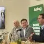Drei Männer bei einer Pressekonferenz sitzen an einem Tisch vor einem Mikrofon