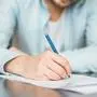 Man writing at the desk. Hands with piece of paper or document and pen. Signing the contract