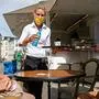 Waitress Antje Roesler (C) serves guests Jens Krugmann (R) and Karin Fanselow (L) at the reopened Cafe Prag in Schwerin, northeastern Germany on May 9, 2020 amid the ongoing Covid-19, coronavirus pandemic. - The traditional cafe and restaurant welcomed sit in customers after two months of closure as restaurants in the state of Mecklenburg Western Pomerania were allowed to reopen under strict hygiene conditions Saturday, May 9, that saw a trickle of returning customers as the north eastern state and Germany are easing corona virus restrictions. (Photo by Odd ANDERSEN / AFP)