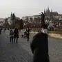 A man wearing a face mask walks across the medieval Charles Bridge in Prague, Czech Republic, Wednesday, Oct. 21, 2020. In another desperate attempt to slow the rise of coronavirus infections in the Czech Republic, Health Minister Roman Prymula has announced a ban on free movement of people in the country and a closure of many stores, shopping malls and hotels. At the same time, state offices will limit their opening hours. Prime Minister Andrej Babis says those measures should prevent the collapse of the health system in early November. (AP Photo/Petr David Josek)