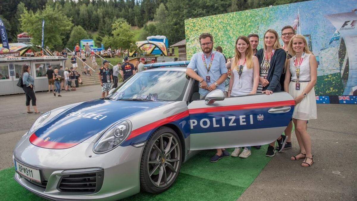 Das Social Media-Team des Innenministeriums vor dem Polizei-Porsche