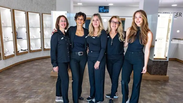 Fünf in Schwarz gekleidete Frauen stehen in einem Juweliergeschäft