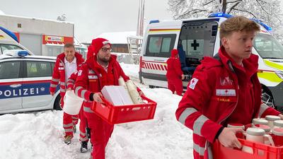 Rotkreuzhelfer bringen Lebensmittel zum Bahnhof, wo rund 200 Zuggäste festsitzen