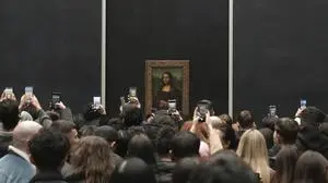 Visitors take photographs from their mobile phone of Leonardo da Vinci's painting of the Mona Lisa, at the Louvre museum, Monday, Jan. 27, 2025 in Paris. (AP Photo/Thibault Camus)