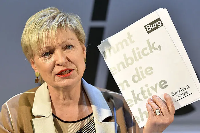 Kušejs Vorgängerin war Karin Bergmann. Von 2014 bis 2019 war sie weniger mit dem künstlerischen Programm befasst, als sie sein wollte: Von ihrem Vorgänger erbte sie tiefe finanzielle Turbulenzen, die das Burgtheater erschütterten und die Gerichte beschäftigten.