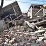 Indian men search through the debris of a collapsed building following a 6.7 magnitude earthquake, in Imphal on December 4, 2015.  At least eight people were killed and scores injured January 4, when a strong 6.7 magnitude earthquake struck northeast India, sending panicked residents fleeing into the streets even hundreds of kilometres away in Bangladesh.   AFP PHOTO/ BIJU BORO,erdbeben indien