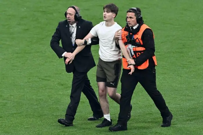 A pitch invader is tackled by stewards during the UEFA Champions League final football match between Borussia Dortmund and Real Madrid, at Wembley stadium, in London, on June 1, 2024. (Photo by JUSTIN TALLIS / AFP)