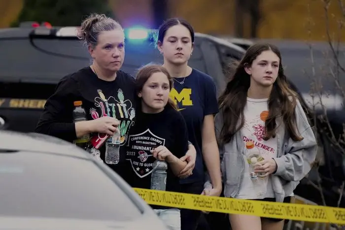 A family leaves the shelter after multiple injuries were reported following a shooting at the Abundant Life Christian School, Monday, Dec. 16, 2024. (AP Photo/Morry Gash)