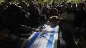 Friends and relatives mourn over the coffin of slain hostage Idan Shtivi, whose body was recovered in an Israeli military operation in the Gaza Strip, during his funeral in Kfar Maas, Israel, Monday, Sept. 1, 2025. (AP Photo/Ariel Schalit)