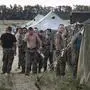 Ukrainian soldiers, who fled the conflict territory, spend their time at a tent camp near the Russia-Ukraine border just outside the village of Gukovo, Rostov-on-Don region, southern Russia, Monday, Aug. 4, 2014. A Russian border security official said Monday that more than 400 Ukrainian soldiers have crossed into Russia. The Russian official said the soldiers deserted the Kiev government and the Russian side opened a safe corridor. (AP Photo/Alexander Zemlianichenko)