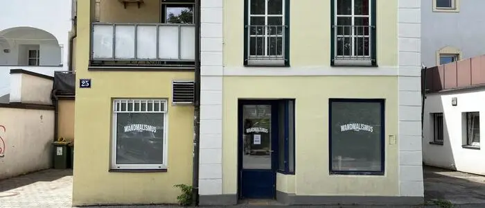 Blick von außen auf ein Innenstadtgebäude in Gelb