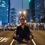 TOPSHOT - A protester (C) sits at the middle of Harcourt Road in Hong Kong after a protest against a controversial extradition law proposal in Hong Kong on June 12, 2019. - Violent clashes broke out in Hong Kong on June 12 as police tried to stop protesters storming the city's parliament, while tens of thousands of people blocked key arteries in a show of strength against government plans to allow extraditions to China. (Photo by Philip FONG / AFP)