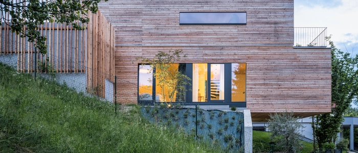 Das Holzhaus schmiegt sich an den Hang