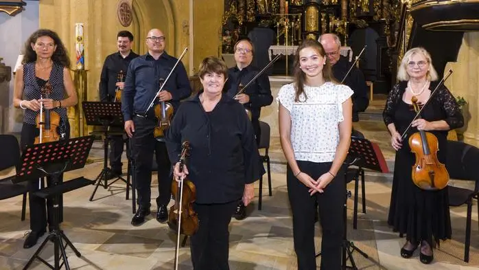 Musikwoche-Organisatorin Lore Schrettner mit Solistin Theresa Sayuri Brunner und der Louis Spohr Sinfonietta in der Pfarrkirche St. Marein