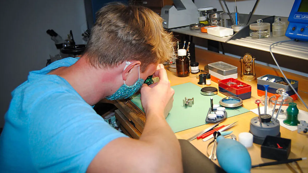 Konzentriert arbeitet der junge Uhrmachermeister an einer seiner Werkbänke