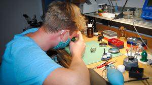 Konzentriert arbeitet der junge Uhrmachermeister an einer seiner Werkbänke
