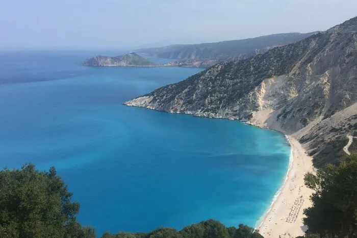 Myrtos Beach, Kefalonia.Mit rund 730 Quadratkilometern ist Kefalonia die größte der Ionischen Inseln und ein wahres Urlaubsparadies. Der berühmteste Strand auf der Insel ist der Myrtos Beach. Traumhaft ist der Blick auf das azurblaue kristallklare Wasser und die Weiten des Meeres. Der weiße Strand mit feinen Kieselsteinchen ist umgeben von malerischen steilen Klippen.