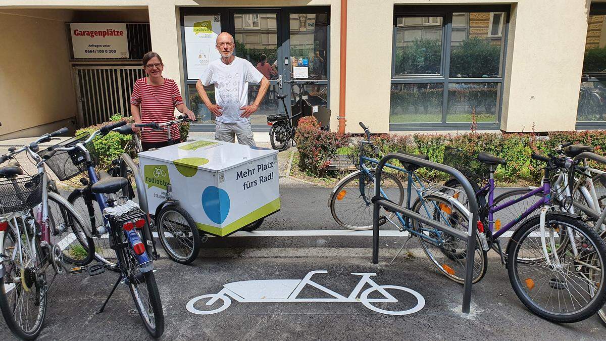 Brigitte Schicho und Walter Bradler von der Argus Radlobby vor dem ersten markierten Lastenradparkplatz in Graz