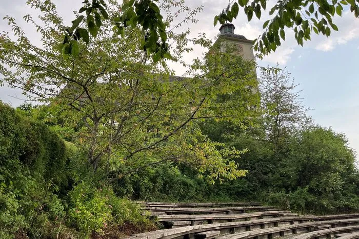 Hinter der Holzarena befindet sich die katholische Kirche von Arriach. Die Sitzgelegenheiten wurden vor der Premiere von der Gemeinde noch restauriert.