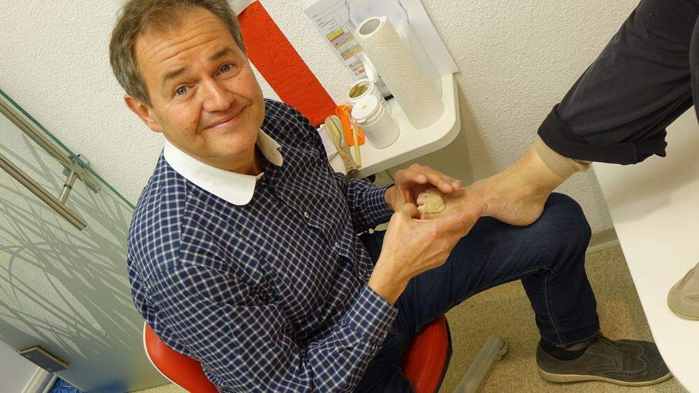 Josef Baumgartner mit seiner Entwicklung - einer Art Knetmasse, die in Schuhen getragen werden kann