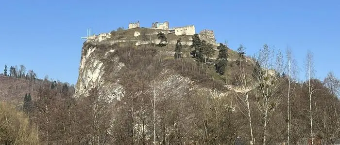 Zu sehen ist ein hoher Berg, darauf thront der Schlossberg in Griffen