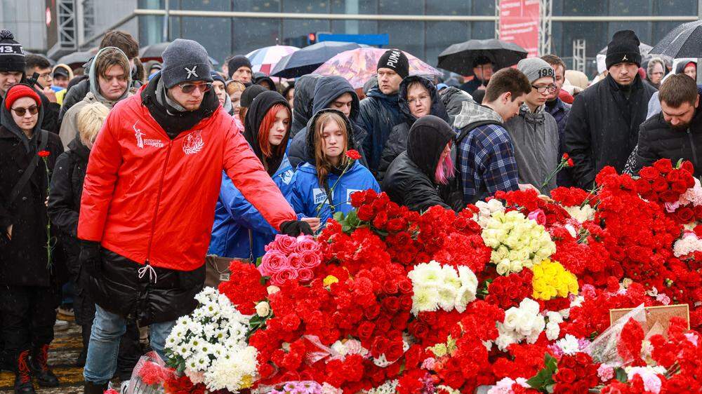 Trauerende legen vor der Crocus City Hall Blumen nieder