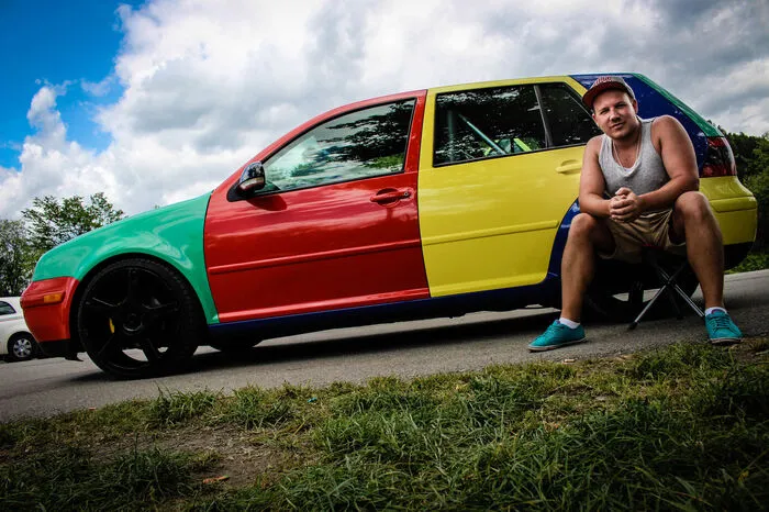 „Der Golf, mit dem ich hier am Treffen bin, ist eigentlich auch mein Alltagsauto. Ursprünglich war er silber, aber ich wollte etwas, dass sonst keiner hat. Die Harlekin-Lackierung gab es ja sogar einmal original bei Volkswagen. Hier in Europa für den VW Polo und in Amerika für den Golf 3. Mir hat das extrem gut gefallen. Allerdings habe ich die Teile nicht lackieren lassen sondern foliert. Die kann ich im Notfall einfach wieder abziehen. Ansonsten hab ich gar nicht so viel gemacht an meinem Auto. Felgen, Fahrwerk und ein Überrollkäfig. Außerdem Spiegel vom Golf 5 und eine US-Leiste vorn. 2005 war ich das ersten Mal nur zum Schauen in Reifnitz, danach nur noch mit eigenem Auto. Heuer ist es wieder super, allerdings gefällt mir das Treffen vor dem Treffen fast besser als das eigentliche Event. Da findet man definitiv die schöneren Autos.“