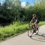 Ein Mann fährt auf seinem Rennrad, im Hintergrund grüne Sträucher