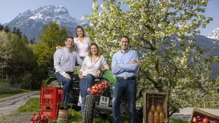 Vier Personen stehen vor einem Obstbaum