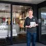 Bernhard Steiner vor dem Shop mit dem Werk "Urlaubsdomizil" von Lois Fasching
