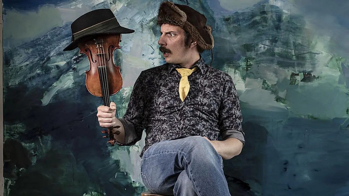 Manfred Plessl mit seiner Geige und einem Bild von Musikerkollege Richard Klammer im Hintergrund 