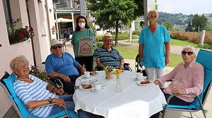 Pflegedienstleitung Ailin Charinceva (links hinten) mit Mitarbeiterin Andrea Semmelrock (rechts hinten) und Bewohnern vom "Haus Abendruh" 
